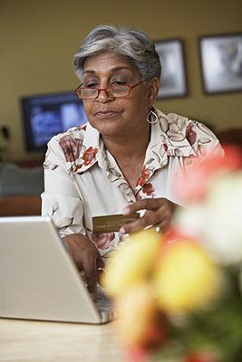 African American senior woman making a purchase on her computer with her credit card